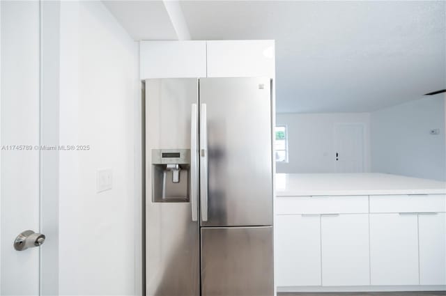 kitchen with light countertops, white cabinetry, stainless steel refrigerator with ice dispenser, and modern cabinets