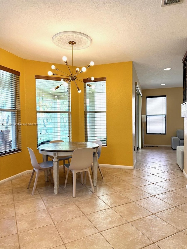 dining room with an inviting chandelier, baseboards, and a textured ceiling