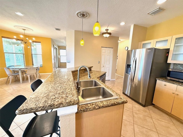 kitchen with a notable chandelier, a breakfast bar, a sink, stainless steel appliances, and visible vents