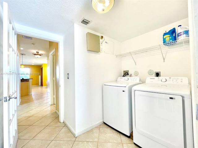 laundry area with washer and dryer, light tile patterned flooring, and visible vents