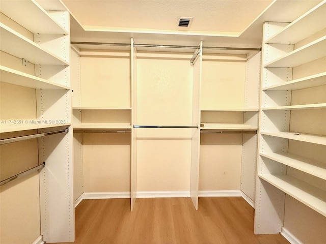spacious closet with light wood-type flooring and visible vents