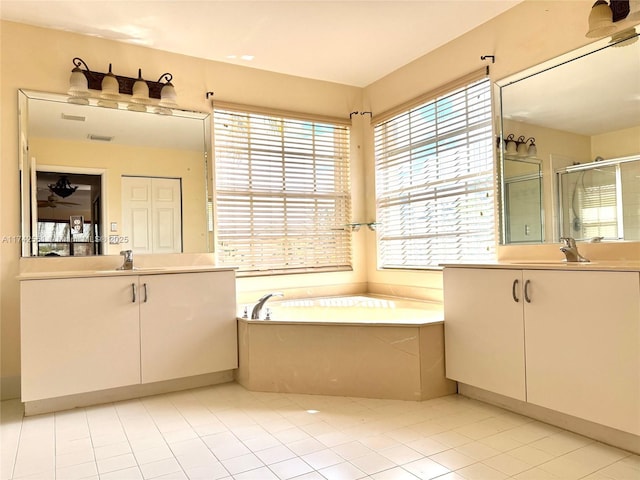 bathroom featuring two vanities, a sink, a shower stall, and a healthy amount of sunlight
