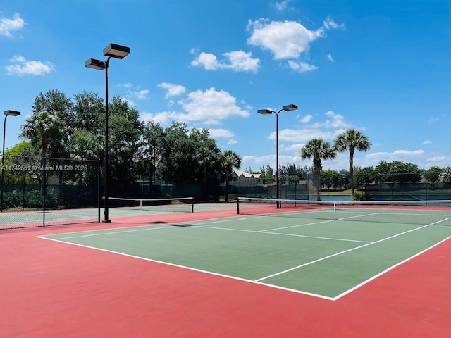view of tennis court with fence and community basketball court