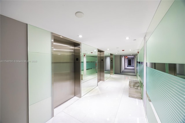 hallway featuring light tile patterned flooring and elevator