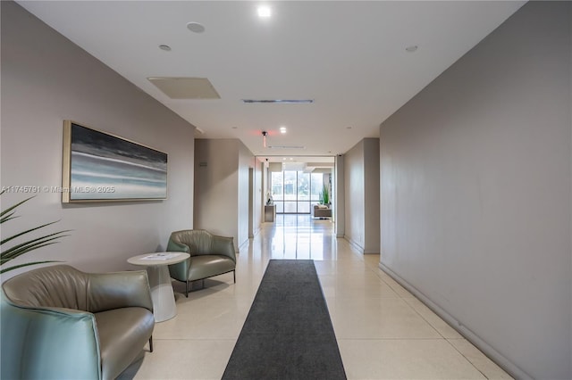 hall with expansive windows and light tile patterned floors