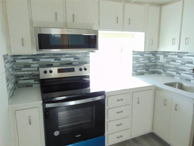 kitchen featuring sink, backsplash, stainless steel appliances, and hardwood / wood-style flooring