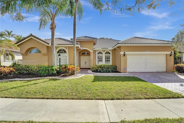 mediterranean / spanish home with a garage and a front yard