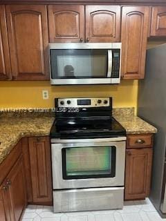 kitchen featuring stone counters and appliances with stainless steel finishes