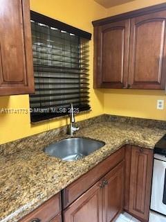 kitchen with sink, white electric range, and stone counters