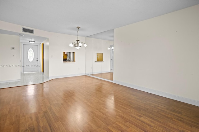 2811 N Pine Island Rd Unit 302, Sunrise, FL 33322 - unfurnished living room featuring visible vents, baseboards, wood finished floors, and a chandelier