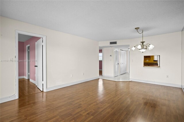 2811 N Pine Island Rd Unit 302, Sunrise, FL 33322 - spare room with a notable chandelier, a textured ceiling, baseboards, wood finished floors, and visible vents