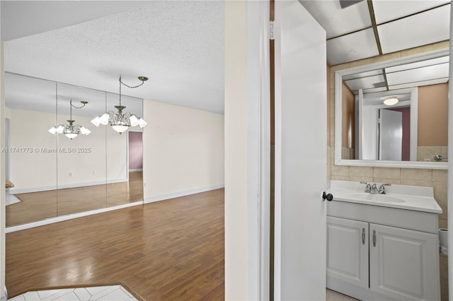 2811 N Pine Island Rd Unit 302, Sunrise, FL 33322 - bathroom with vanity, baseboards, wood finished floors, and a notable chandelier