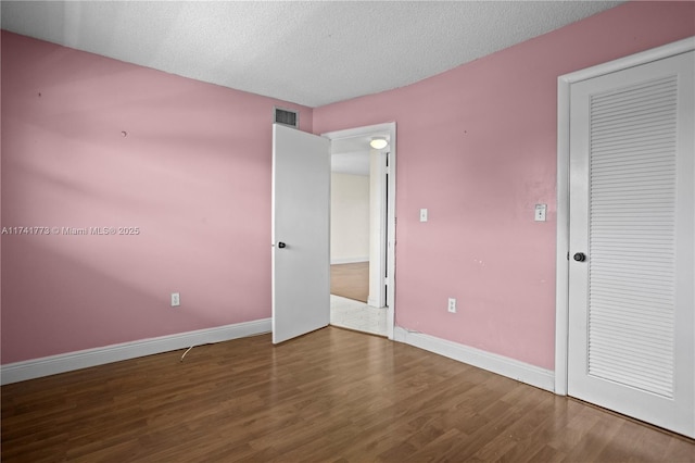2811 N Pine Island Rd Unit 302, Sunrise, FL 33322 - unfurnished bedroom with baseboards, a textured ceiling, wood finished floors, and visible vents
