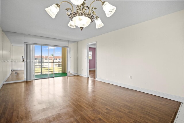 2811 N Pine Island Rd Unit 302, Sunrise, FL 33322 - spare room featuring an inviting chandelier, baseboards, wood finished floors, and expansive windows