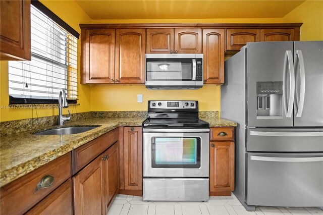 2811 N Pine Island Rd Unit 302, Sunrise, FL 33322 - kitchen featuring stainless steel appliances, stone countertops, brown cabinetry, and a sink