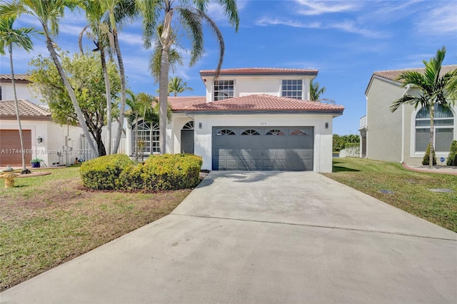 mediterranean / spanish home with driveway, a tile roof, an attached garage, a front lawn, and stucco siding