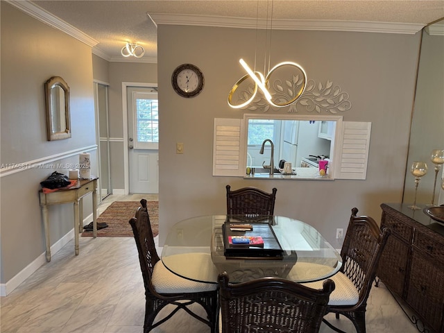 dining space with ornamental molding, sink, a textured ceiling, and a notable chandelier