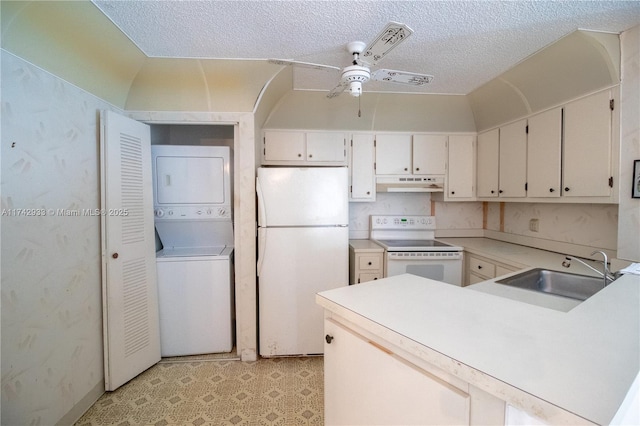 kitchen featuring white cabinetry, sink, stacked washer / drying machine, white appliances, and a textured ceiling