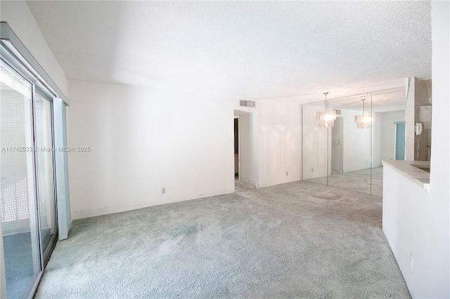 7511 S Oriole Blvd Unit 201, Delray Beach, FL 33446 - empty room featuring light carpet, a chandelier, and a textured ceiling
