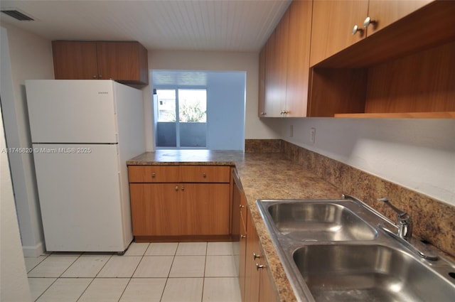 kitchen featuring sink, white fridge, and light tile patterned floors