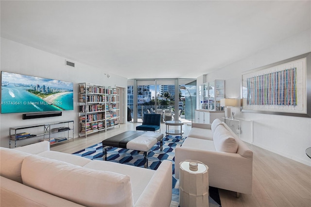 living room with light hardwood / wood-style flooring and floor to ceiling windows