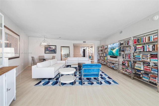 living room with light hardwood / wood-style floors and a chandelier