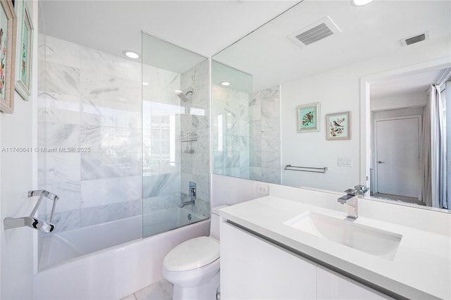 full bathroom with tiled shower / bath, vanity, and toilet