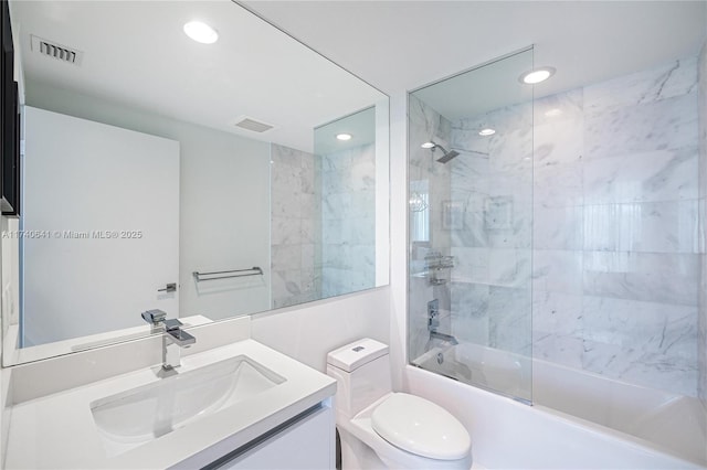 full bathroom featuring vanity, tiled shower / bath combo, and toilet