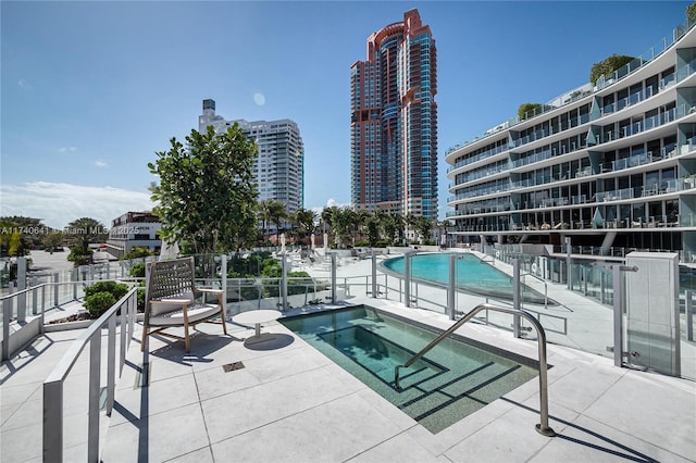 view of pool with a community hot tub and a patio area