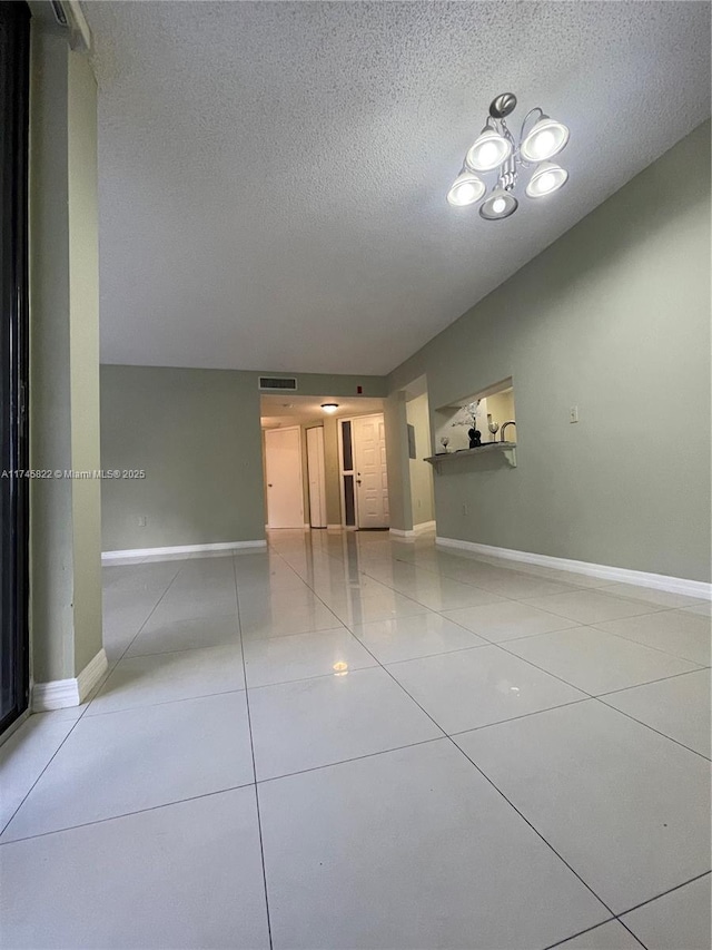 unfurnished room with light tile patterned floors and a textured ceiling