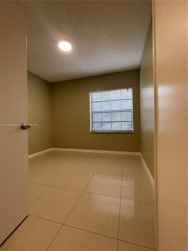 empty room featuring tile patterned floors and a textured ceiling