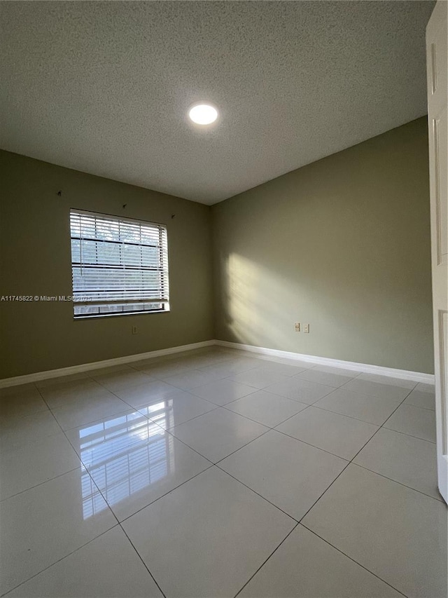 unfurnished room featuring light tile patterned floors and a textured ceiling