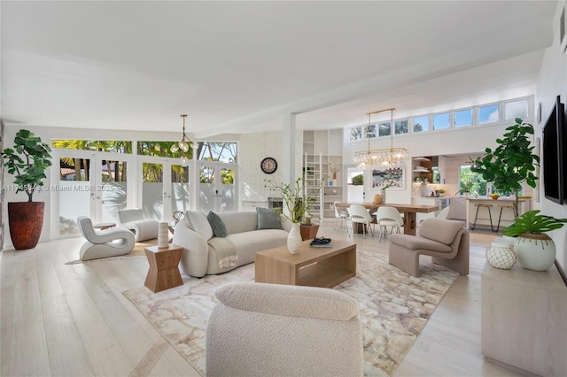 living room featuring light hardwood / wood-style flooring, french doors, and a chandelier