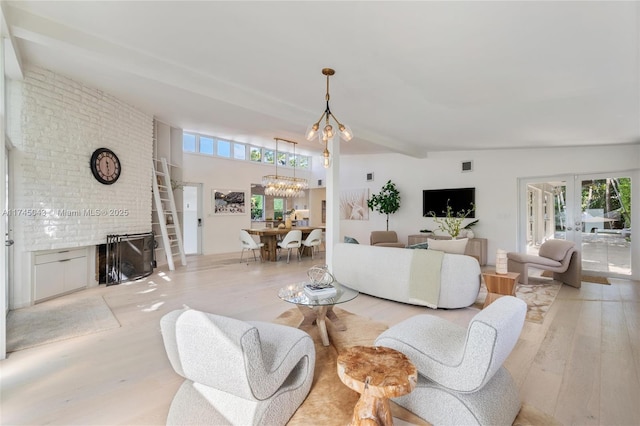 living room featuring a healthy amount of sunlight, an inviting chandelier, light wood-type flooring, and french doors