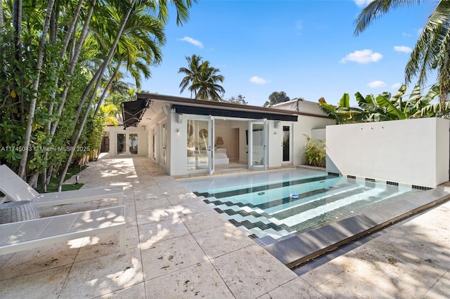 exterior space with a fenced in pool and a patio area