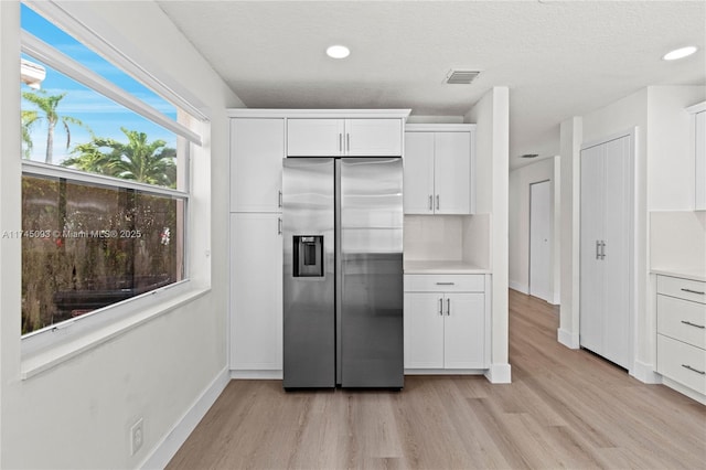 17356 SW 21st St, Miramar, FL 33029 - kitchen featuring stainless steel refrigerator with ice dispenser, light wood-style floors, white cabinets, light countertops, and recessed lighting