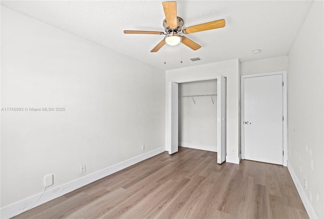 unfurnished bedroom with light hardwood / wood-style floors, a closet, and ceiling fan