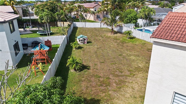 view of yard featuring a playground and a trampoline