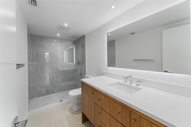 bathroom featuring vanity, tile patterned floors, toilet, and tiled shower