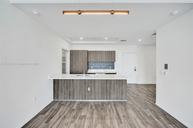 kitchen featuring kitchen peninsula, sink, and hardwood / wood-style floors