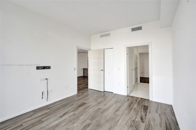 unfurnished bedroom featuring light hardwood / wood-style floors and ensuite bathroom