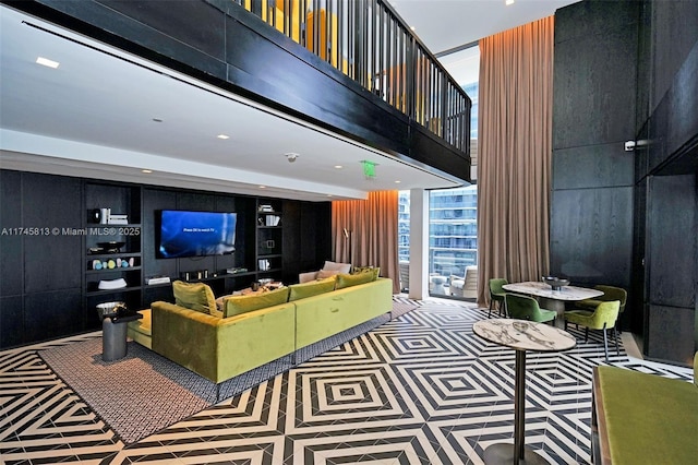 living room featuring wooden walls and a high ceiling