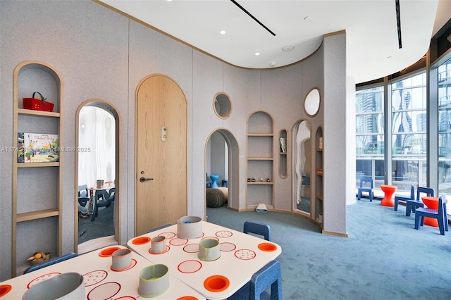 dining area featuring floor to ceiling windows, carpet, and built in features