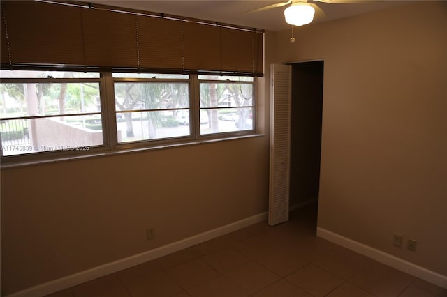 empty room featuring tile patterned flooring and ceiling fan