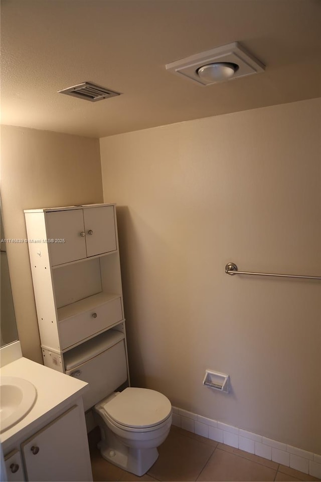 bathroom with tile patterned flooring, vanity, and toilet