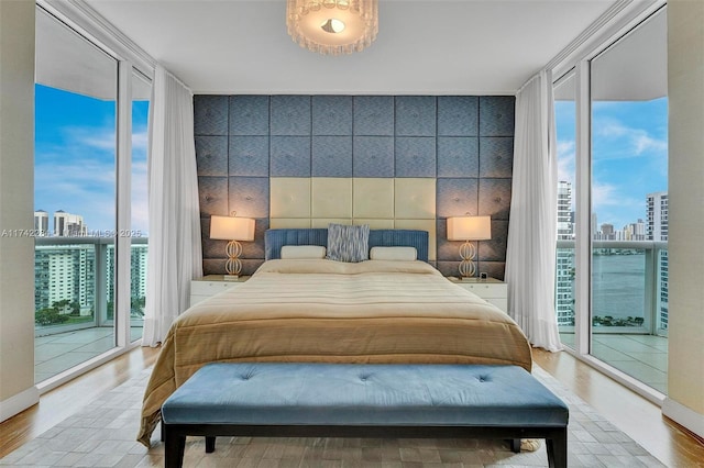 bedroom with expansive windows, access to outside, and a city view