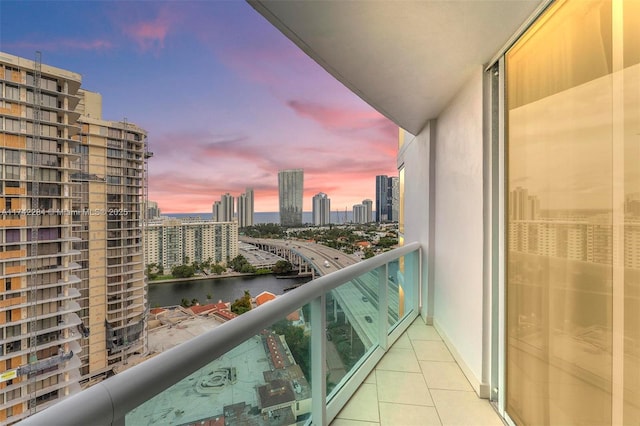 balcony at dusk with a water view and a city view