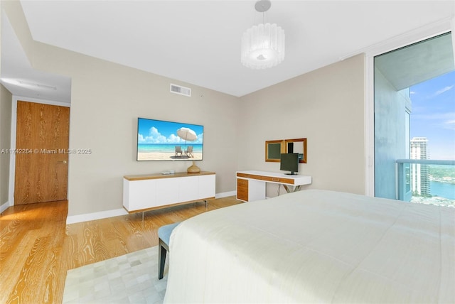 bedroom featuring visible vents, baseboards, and wood finished floors