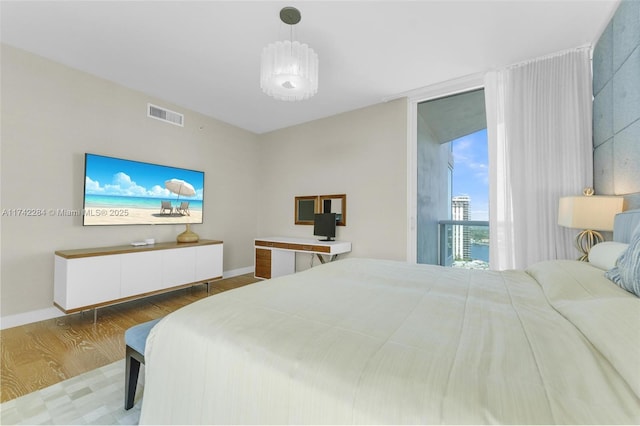 bedroom featuring baseboards, visible vents, and wood finished floors