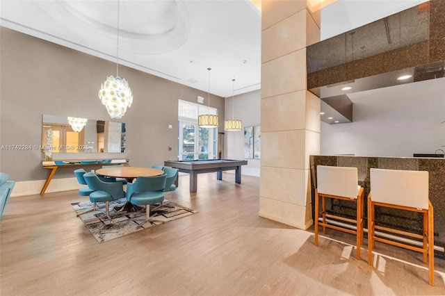 dining area with billiards, a high ceiling, and wood finished floors